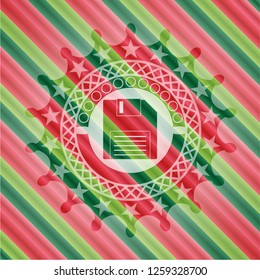 diskette icon inside christmas colors emblem.