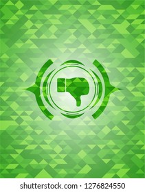dislike icon inside green emblem. Mosaic background