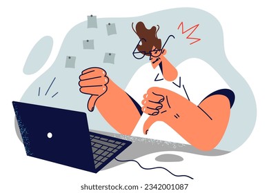 Dissatisfied man freelancer showing thumbs down sitting at table with laptop and calling for fixing software bugs. Dissatisfied guy programmer showing negative feedback during video call