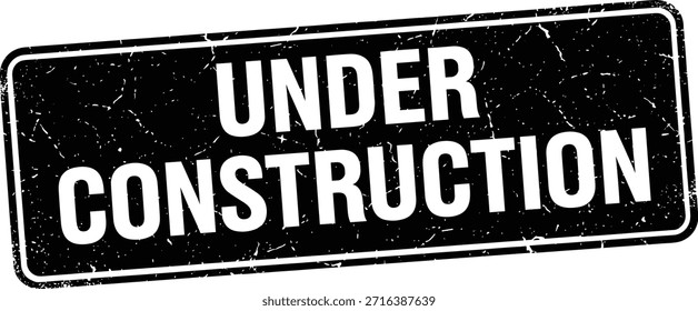 Ein bedrücktes, rechteckiges Schild mit den Worten "UNDER CONSTRUCTION" in fett weißer Schrift. Das Schild hat ein altes, verwittertes Aussehen.