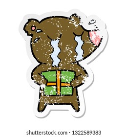 distressed sticker of a cartoon crying bear with present