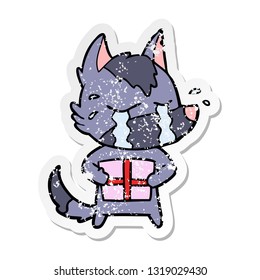 distressed sticker of a cartoon crying wolf with christmas present