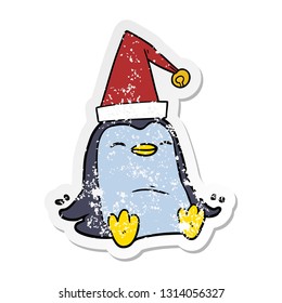 distressed sticker of a cartoon penguin wearing christmas hat