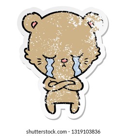 distressed sticker of a crying cartoon bear with folded arms