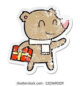 adesivo angustiado de um urso amigável com presente xmas e cachecol
