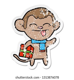 distressed sticker of a funny cartoon monkey with christmas present