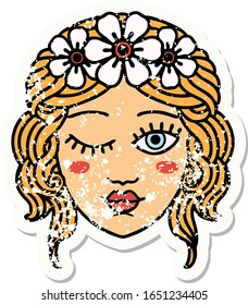 distressed sticker tattoo in traditional style of a maidens face winking