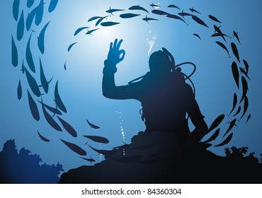 The diver swims among corals in a jamb of fishes