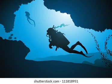 Divers float among corals and fishes