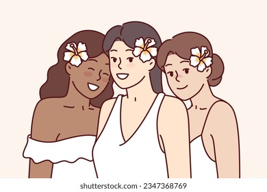 Diversas hermosas mujeres con flores en el pelo están vestidas con elegantes vestidos para la ceremonia de boda. Tres jóvenes novias multiculturales en ceremonia de boda o asistentes a fiesta blanca