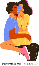 A diverse cuddling couple taking a selfie on a smartphone. Man and woman hugging and kissing. A concept of modern relationship and young love. Blogger lifestyle.