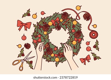 Diy christmas wreath made from green fir branches and red bows or pine cones for interior decoration. Process of making christmas wine to prepare for new year holidays or xmas eve.