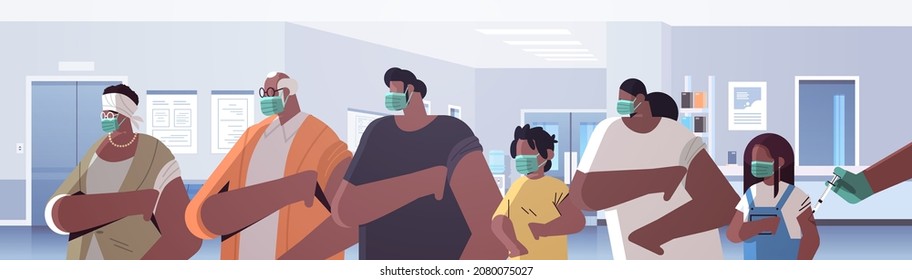 Hand des Arztes, der mehrjährige Familienpatienten in der medizinischen Maske gegen die Entwicklung eines Koronavirus-Impfstoffs impft