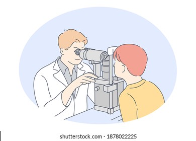 Doctor, medicine, ophthalmologist concept. Young smiling man doctor optometrist examining eyes of little boy patient with special equipment in medical clinic. Medicare, therapist, healthcare 