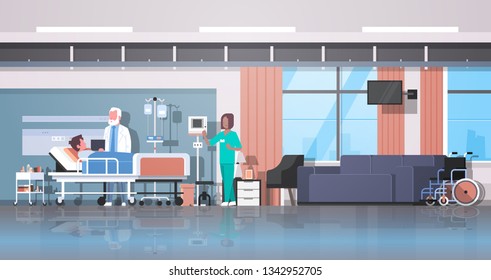 doctor and nurse visiting patient man lying bed with dropper intensive therapy ward healthcare concept hospital room interior modern medical clinic horizontal banner full length