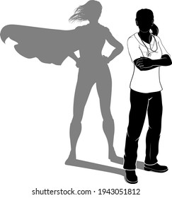 A doctor or nurse woman in silhouette wearing scrubs revealed as a super hero by her shadow.