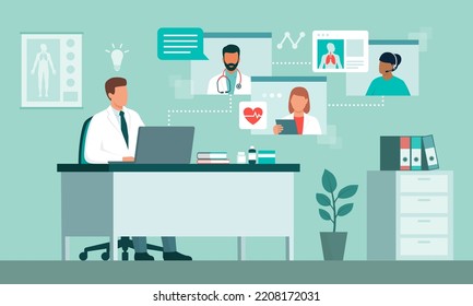 Doctor sitting at desk and working with a laptop, he is having a conference call with other healthcare professionals online and accessing electronic medical records