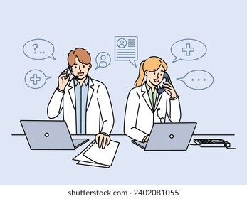 Doctors work in clinic telephone helpline and answer patients questions by phone standing near table with papers and computers. Two doctors with smile sign up clients for session with therapist