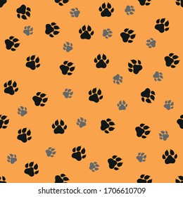 Dogs paws traces. Vector illustration. Black and grey stamps on orange background. Seamless pattern. For logo, wallpaper, fabric, packing, wrapper, scrapbooking, digital paper