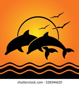 dolphin silhouettes on sunset background