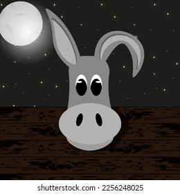 The donkey's head looks out of the wooden pen. Adorable burro against night sky background with moon and stars. Creative flat picture with farm animal.