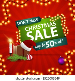 Dont miss, Christmas sale. Red and green discount banner with gift with Santa Claus hat, candles, Christmas tree branch and Christmas ball