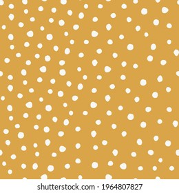 Doodle seamless pattern with hand drawn white spots on a yellow background. Monochrome vector background.  Perfect for kids production.