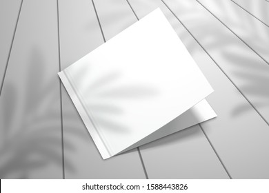 A double postcard lies on the plank floor. Realistic template for design with shadow from palm leaves