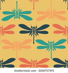 Dragonflies of different colors on a yellow background. Seamless modern insect pattern for trendy fabrics, textiles, throw pillows. Vector.