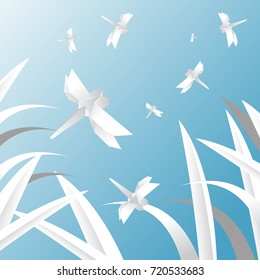 Dragonflies fly in the sky above the grass.