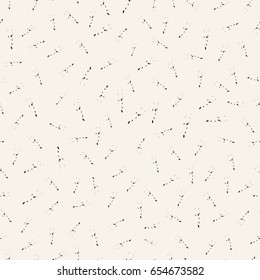 Drawing randomly scattered strokes with spots. Vector seamless pattern.White and black
