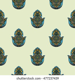 Drawing of a seamless pattern with hamsa in blue, yellow and orange colors, on light green background