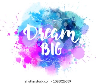 Dream big hand lettering phrase on watercolor imitation color splash.  With floral leaves abstract decoration. Modern calligraphy inspirational quote. Vector illustration.