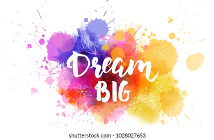 Dream big hand lettering phrase on watercolor imitation color splash.  With floral leaves abstract decoration. Modern calligraphy inspirational quote. Vector illustration.