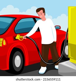 Fahrer, der ein rotes Auto an einer Tankstelle betankt.