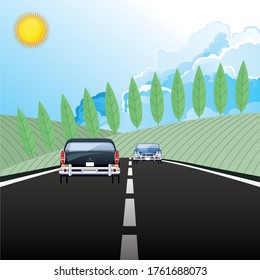 Drivers travelling along a country road with blue cloudy sky 
