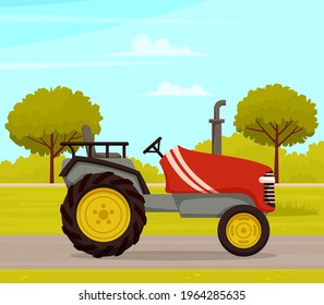 Driving tractor on road near meadow on nature landscape. Driving red tractor, agrimotor cabin. Agriculture driver profession harvesting and cultivation in summer in countryside