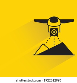 drone scanning terrain with shadow on yellow background