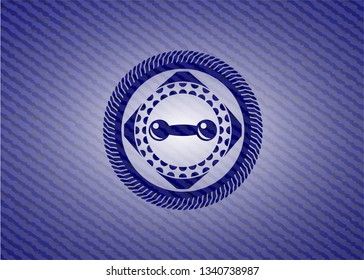 dumbbell icon inside badge with denim background