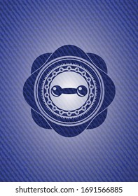 dumbbell icon inside badge with denim background. 