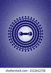 dumbbell icon inside badge with denim background. 