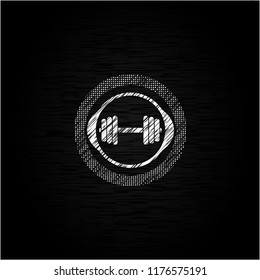 dumbbell icon inside chalk emblem written on a blackboard