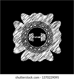 dumbbell icon inside chalk emblem written on a blackboard