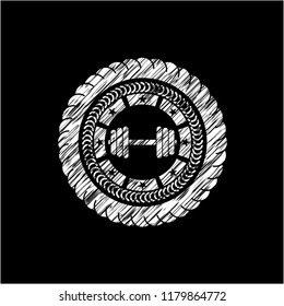 dumbbell icon inside chalkboard emblem written on a blackboard