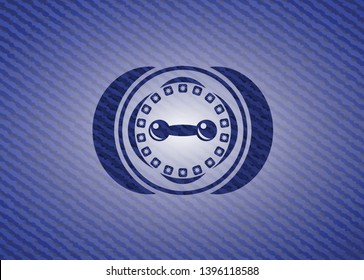 dumbbell icon inside emblem with jean background