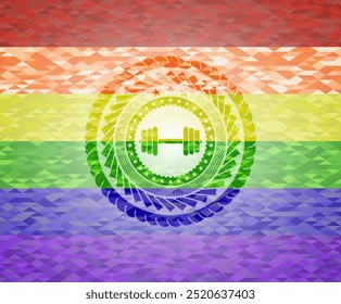 Icono de mancuerna dentro del emblema sobre fondo de mosaico con los colores de la bandera LGBT. 
