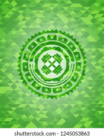 dumbbell icon inside green emblem with mosaic background