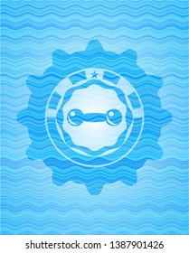 dumbbell icon inside light blue water wave style emblem.