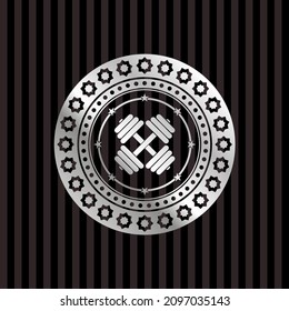 dumbbell icon inside silver emblem or badge. 