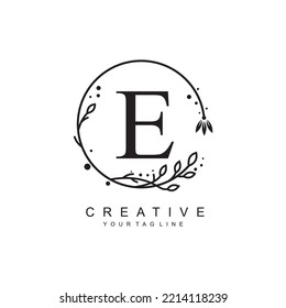 E letter logo design with floral frame ornaments and circular leaves. the letter E design is beautiful and luxurious. E monogram typography. suitable for beauty, business, company, promotion logo etc